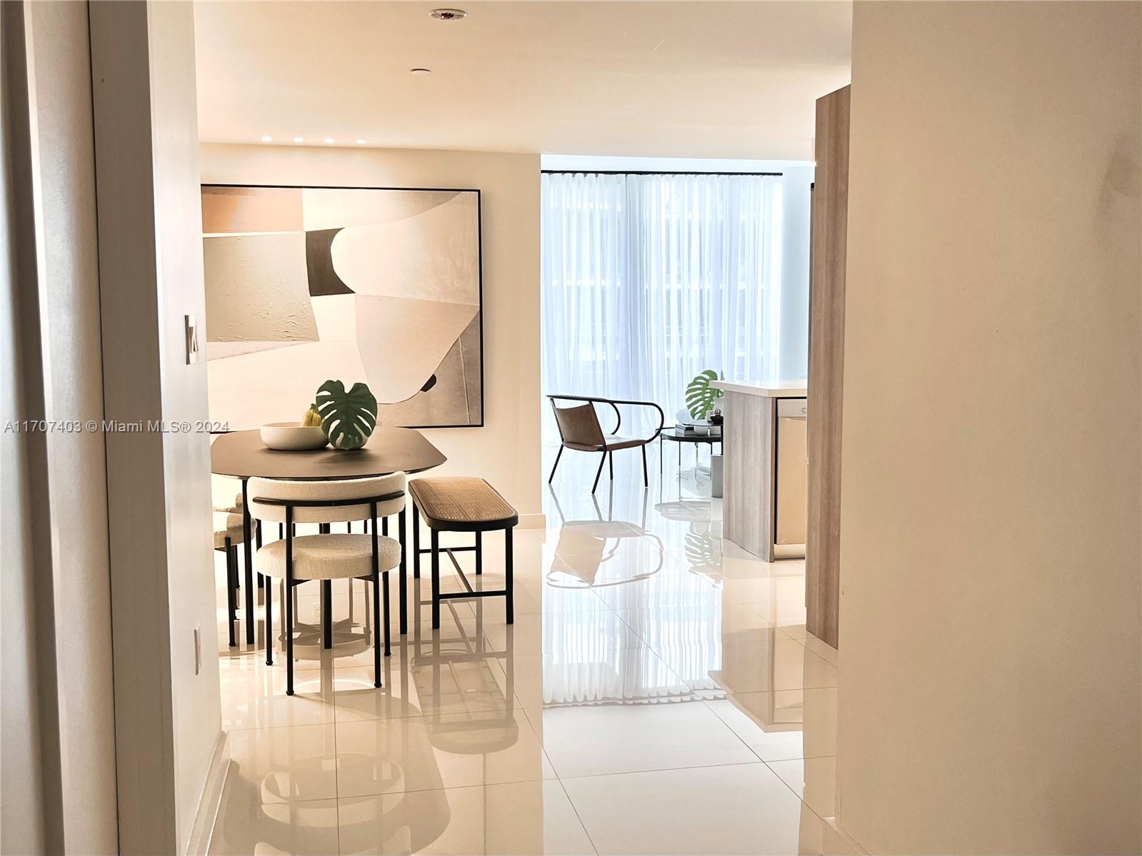 a dining room with furniture and a floor to ceiling window