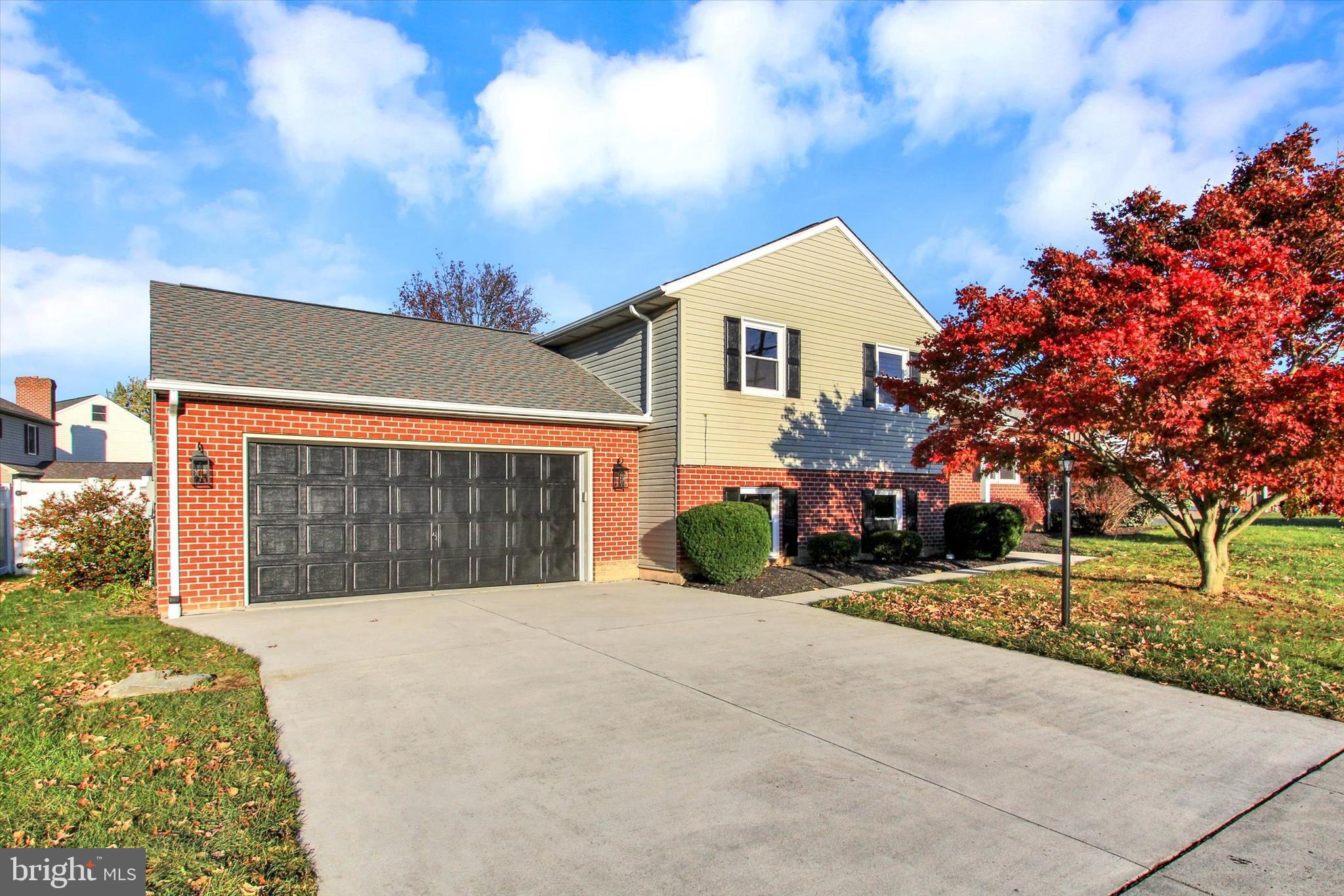 a view of house with garage and yard