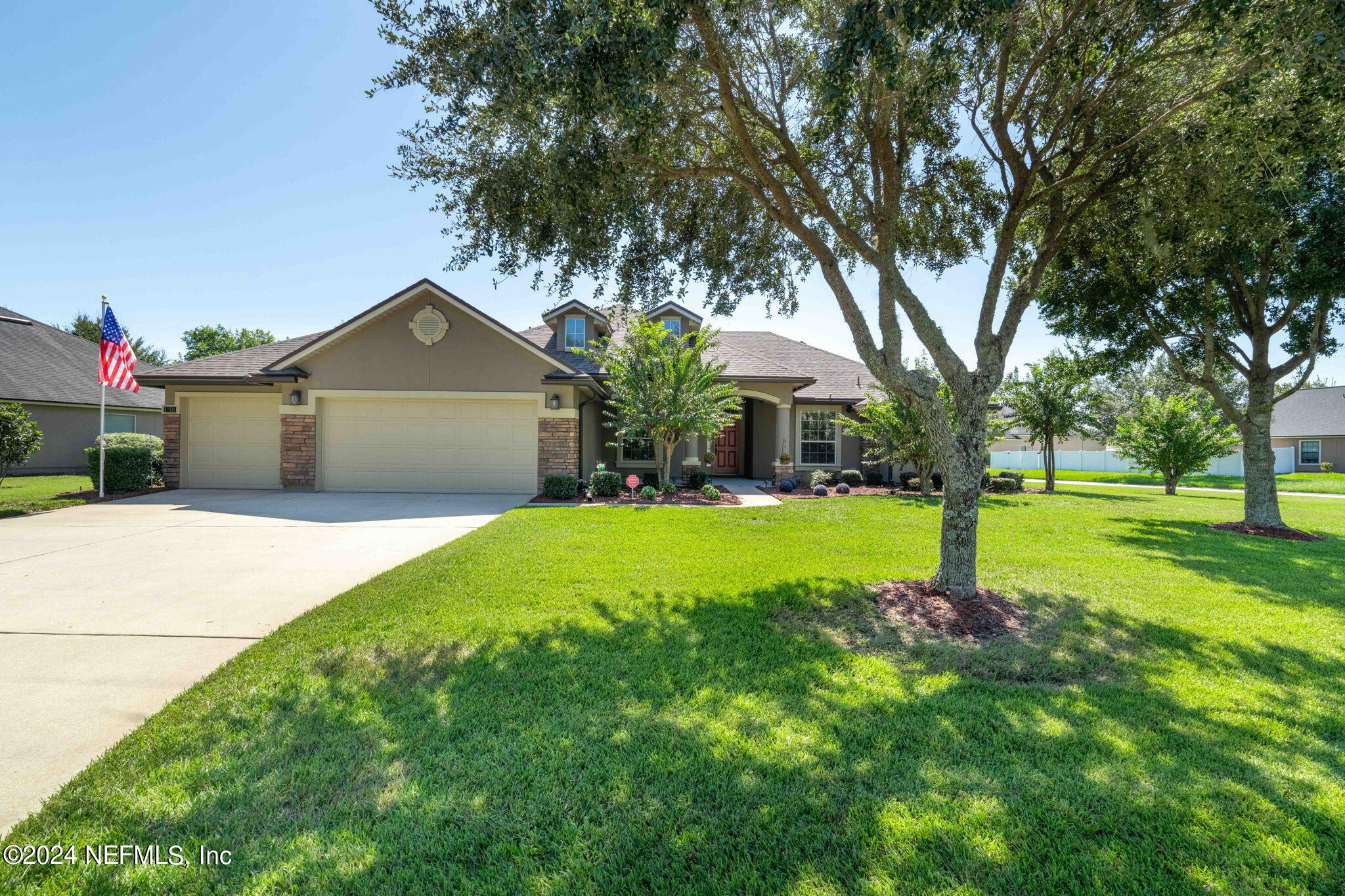 a front view of a house with yard and green space