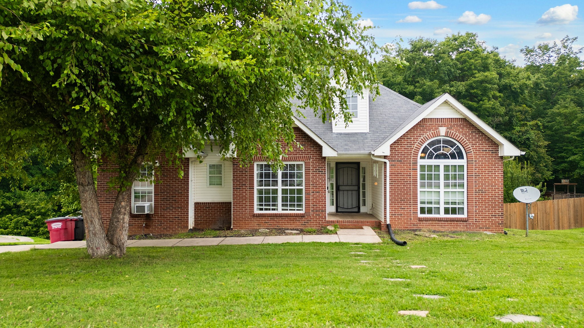 a front view of a house with a garden and yard