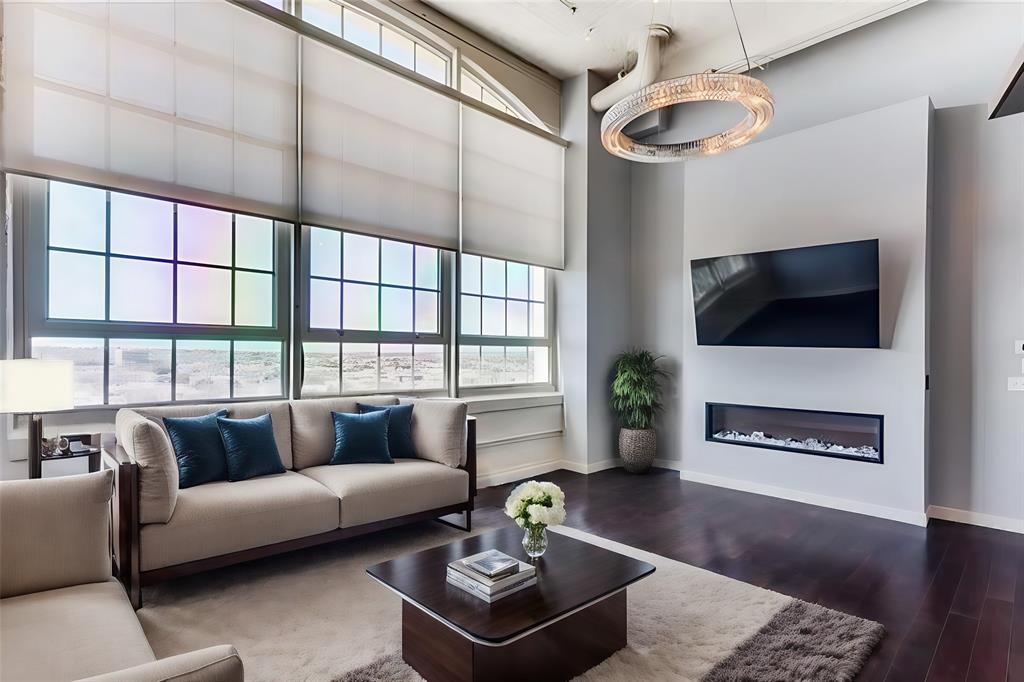 a living room with furniture a flat screen tv and a large window