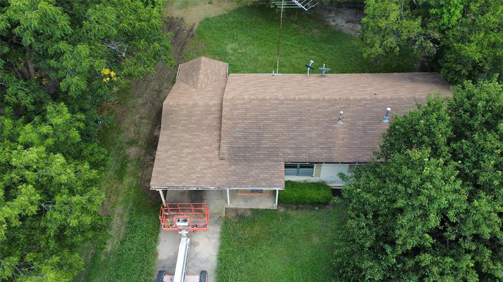 an aerial view of a house with a yard and a large tree