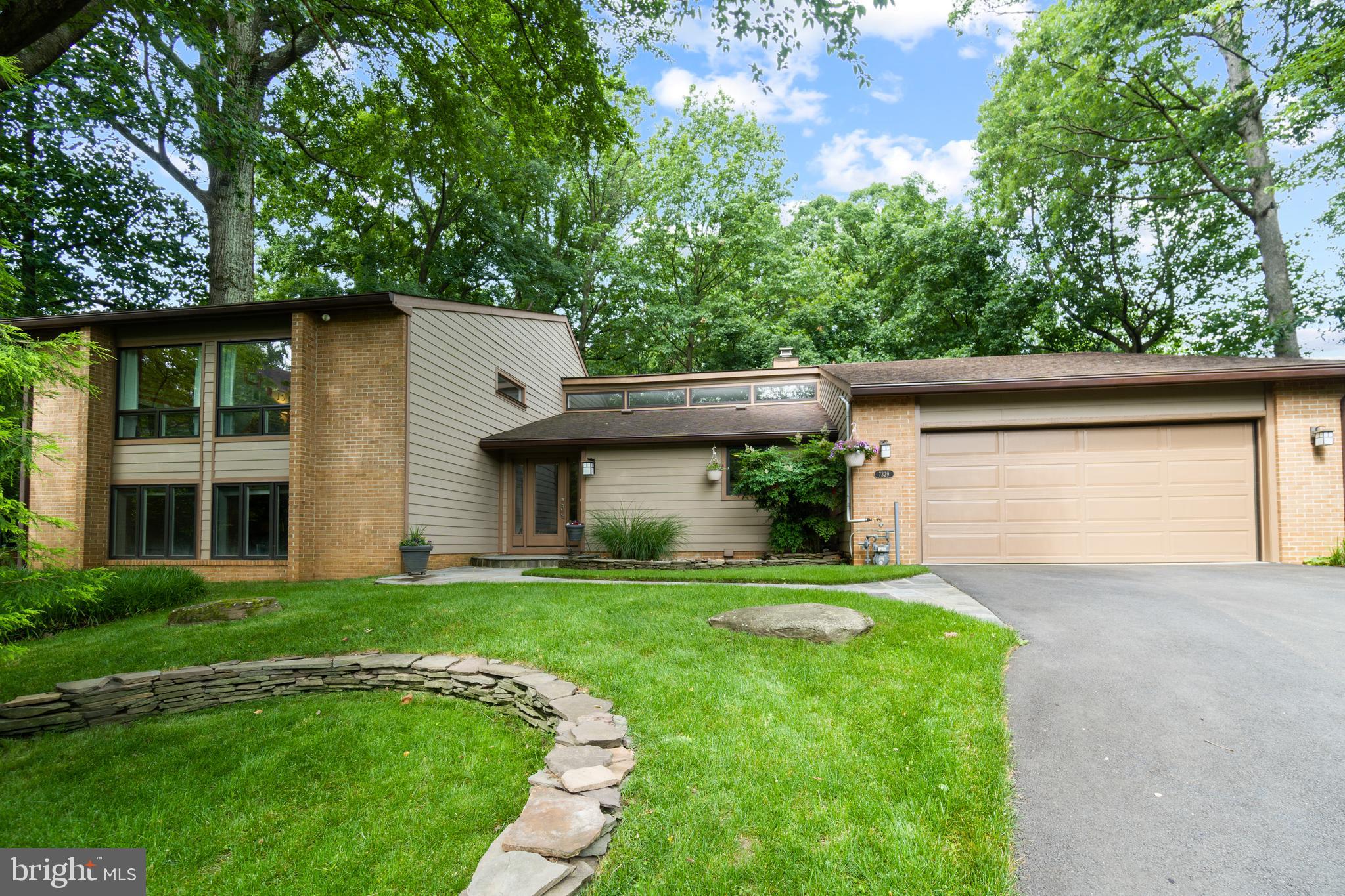 a front view of a house with a yard and trees