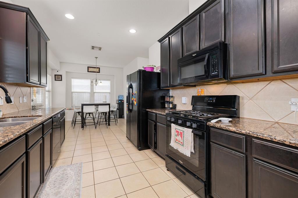 a kitchen with stainless steel appliances granite countertop a stove refrigerator and a microwave