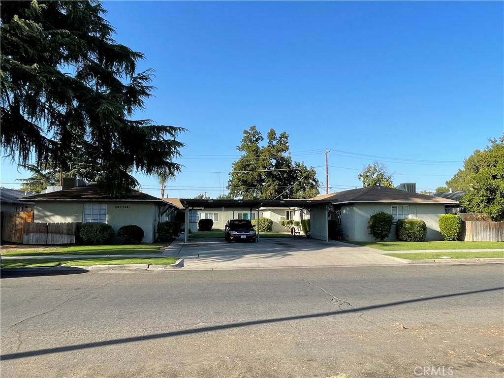 a view of a house with a yard and a car parked in front of it