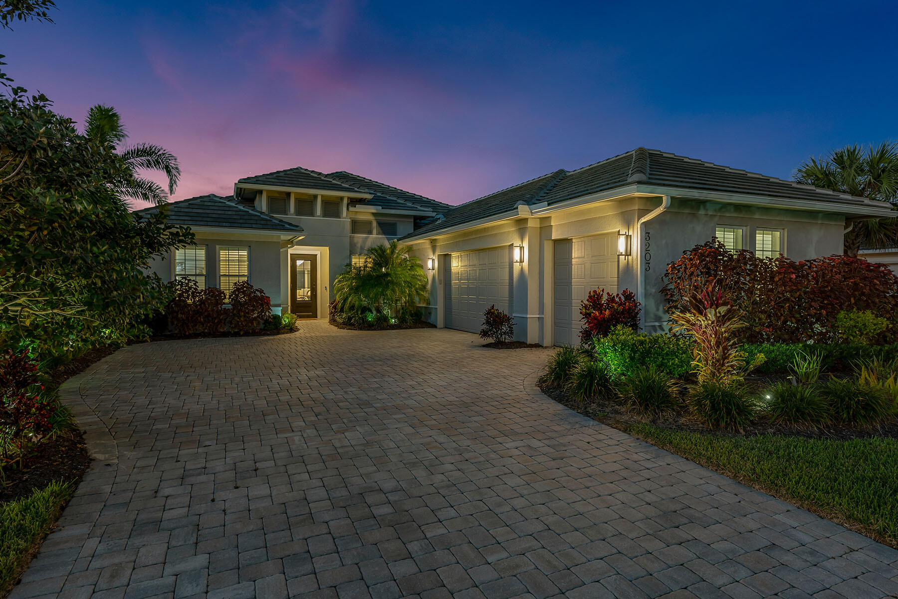 a front view of a house with yard and green space