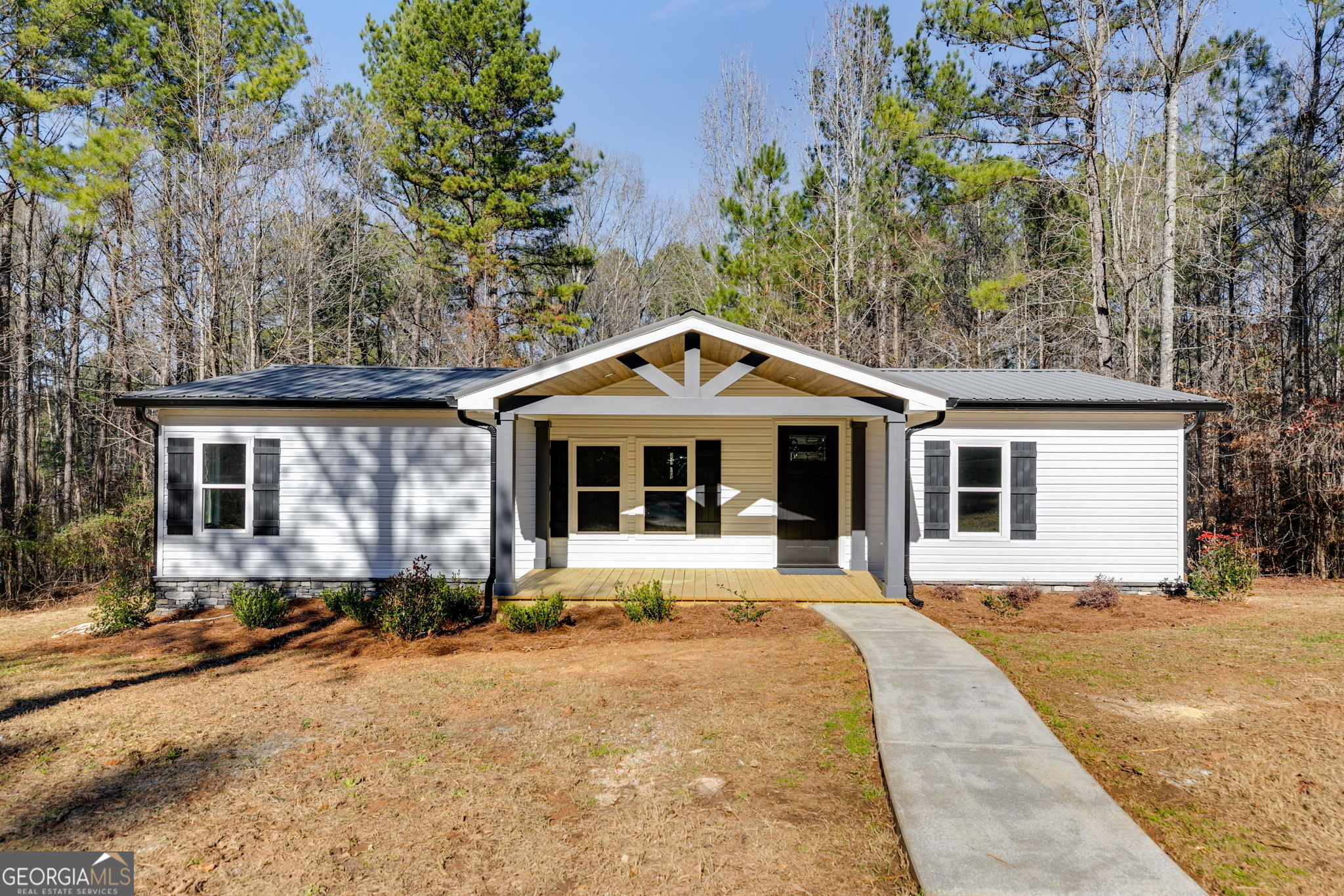 a front view of house with yard and trees around