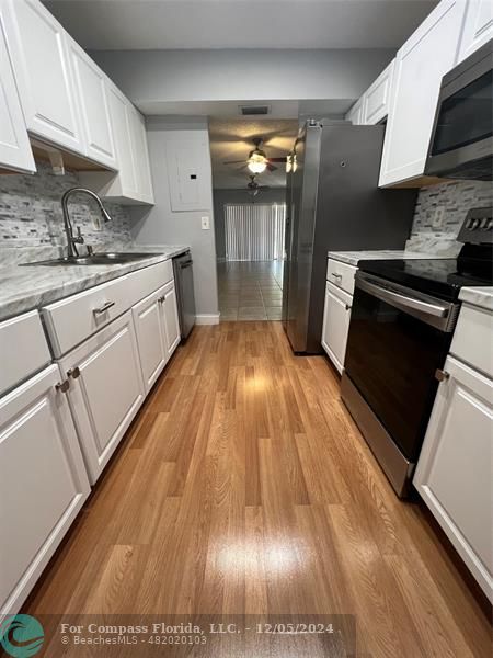 a kitchen with cabinets and wooden floor