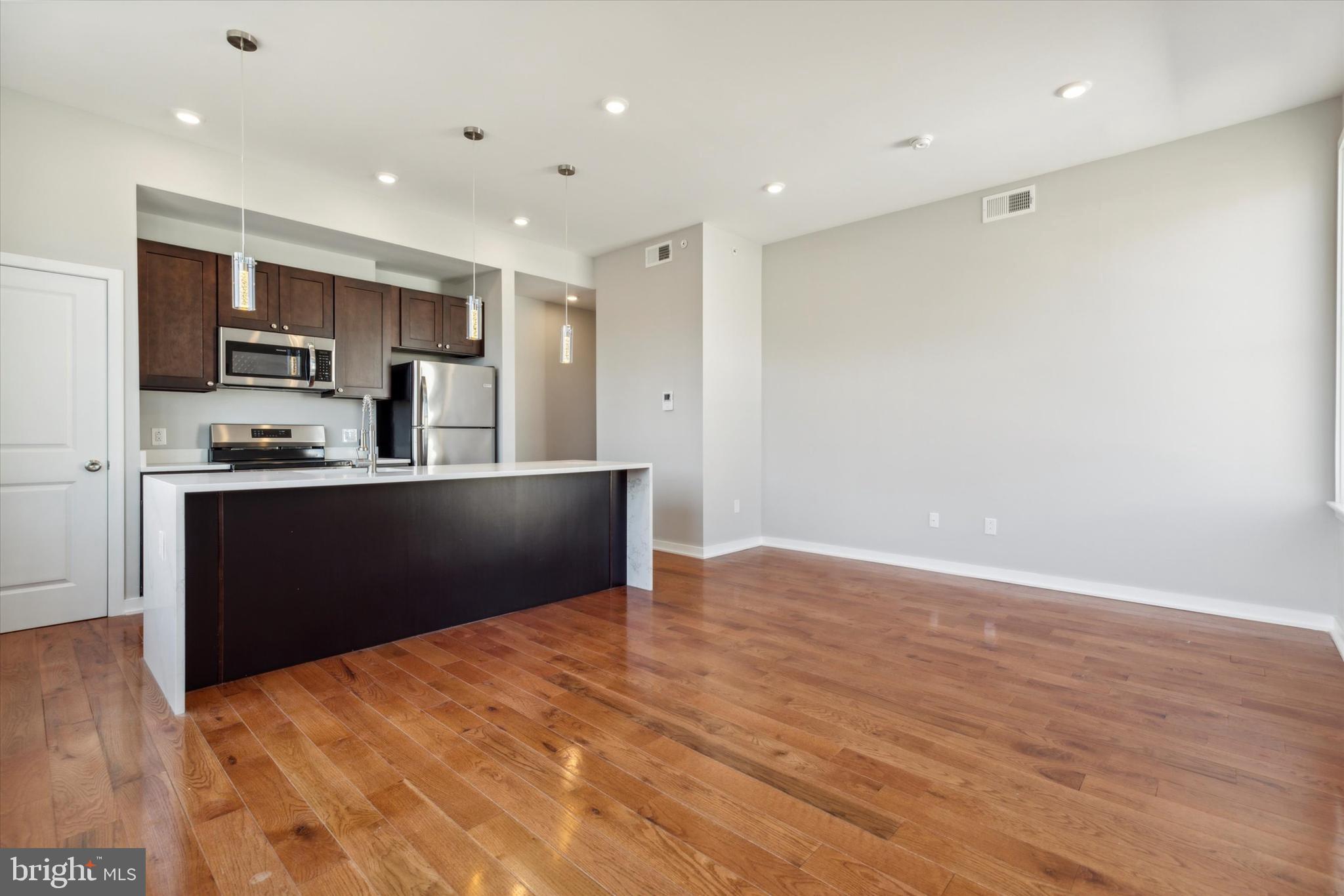 a kitchen with stainless steel appliances kitchen island a refrigerator sink and cabinets