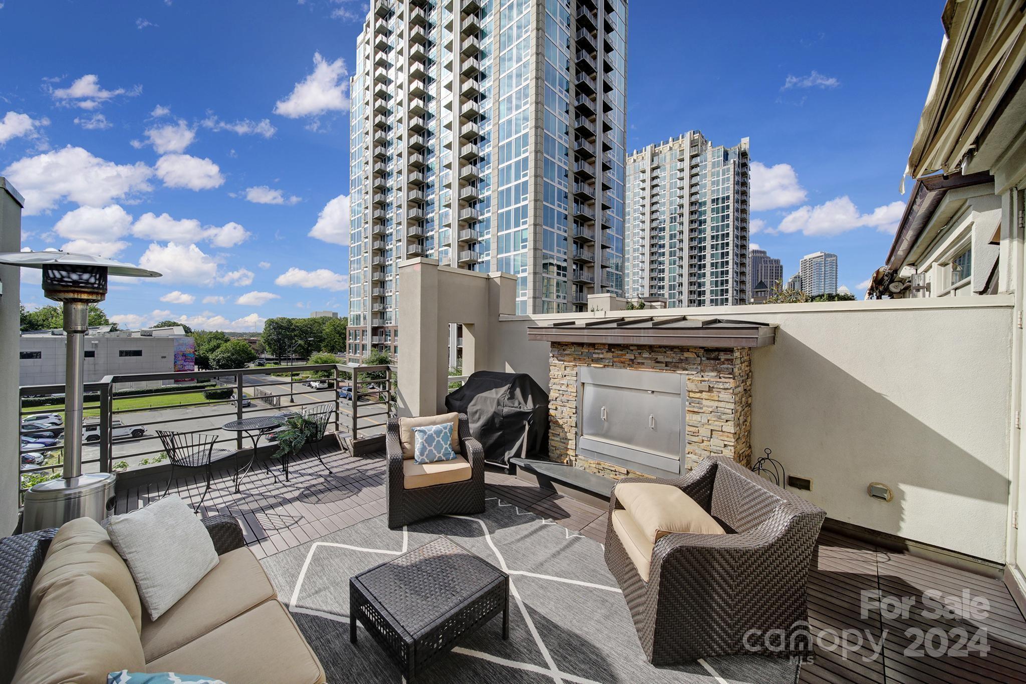 a view of a roof deck with couches and potted plants