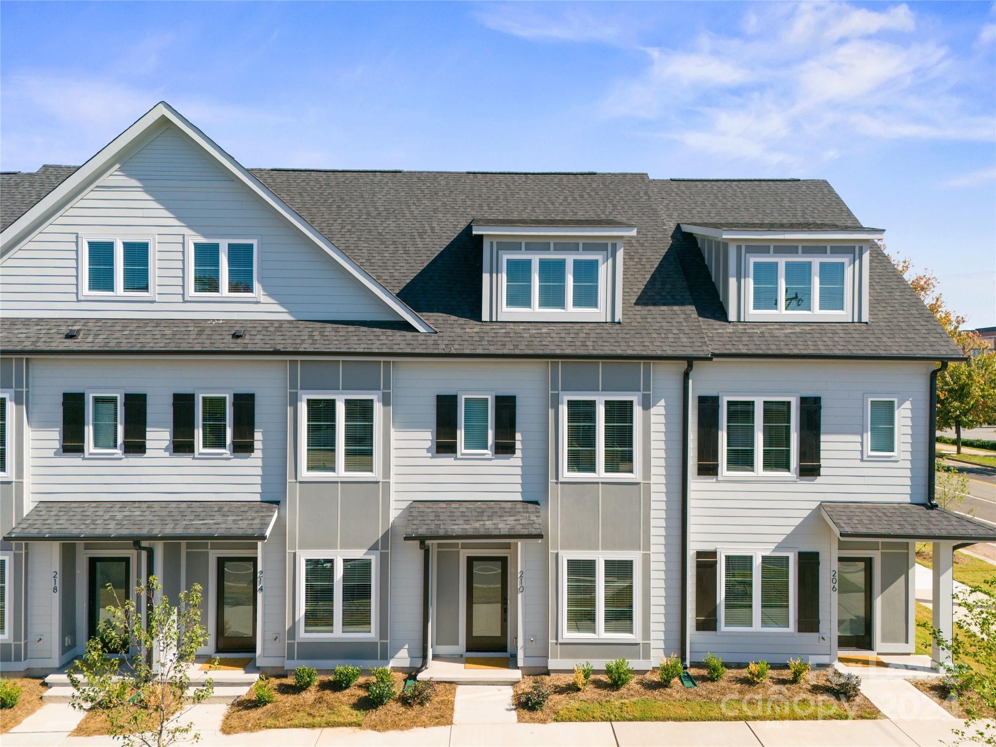 a front view of a residential apartment building with a yard