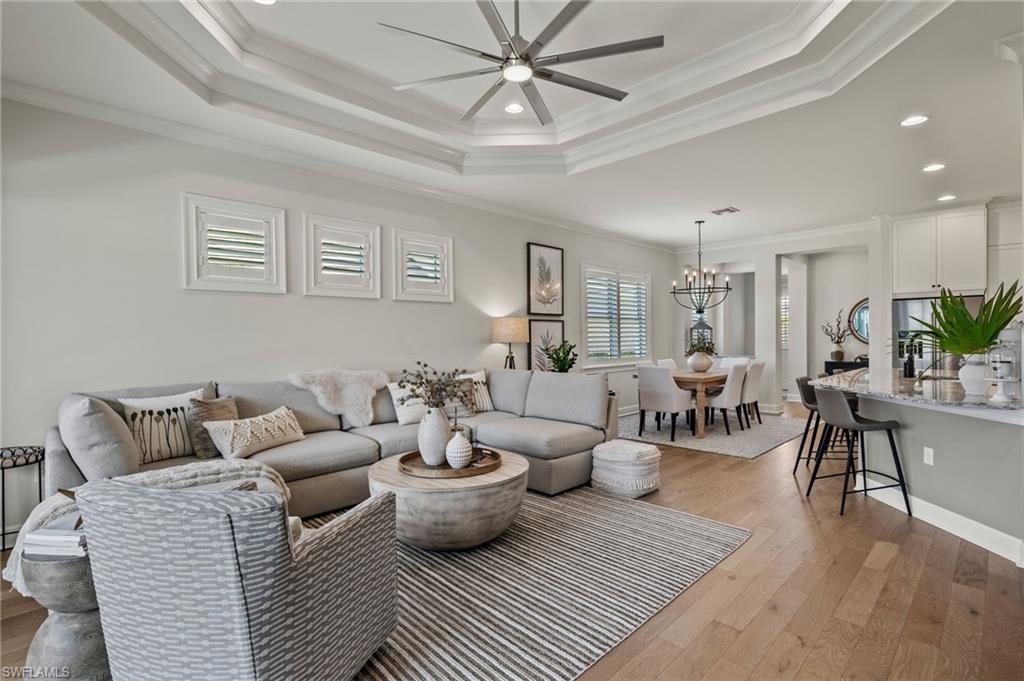 a living room with lots of white furniture and view of kitchen