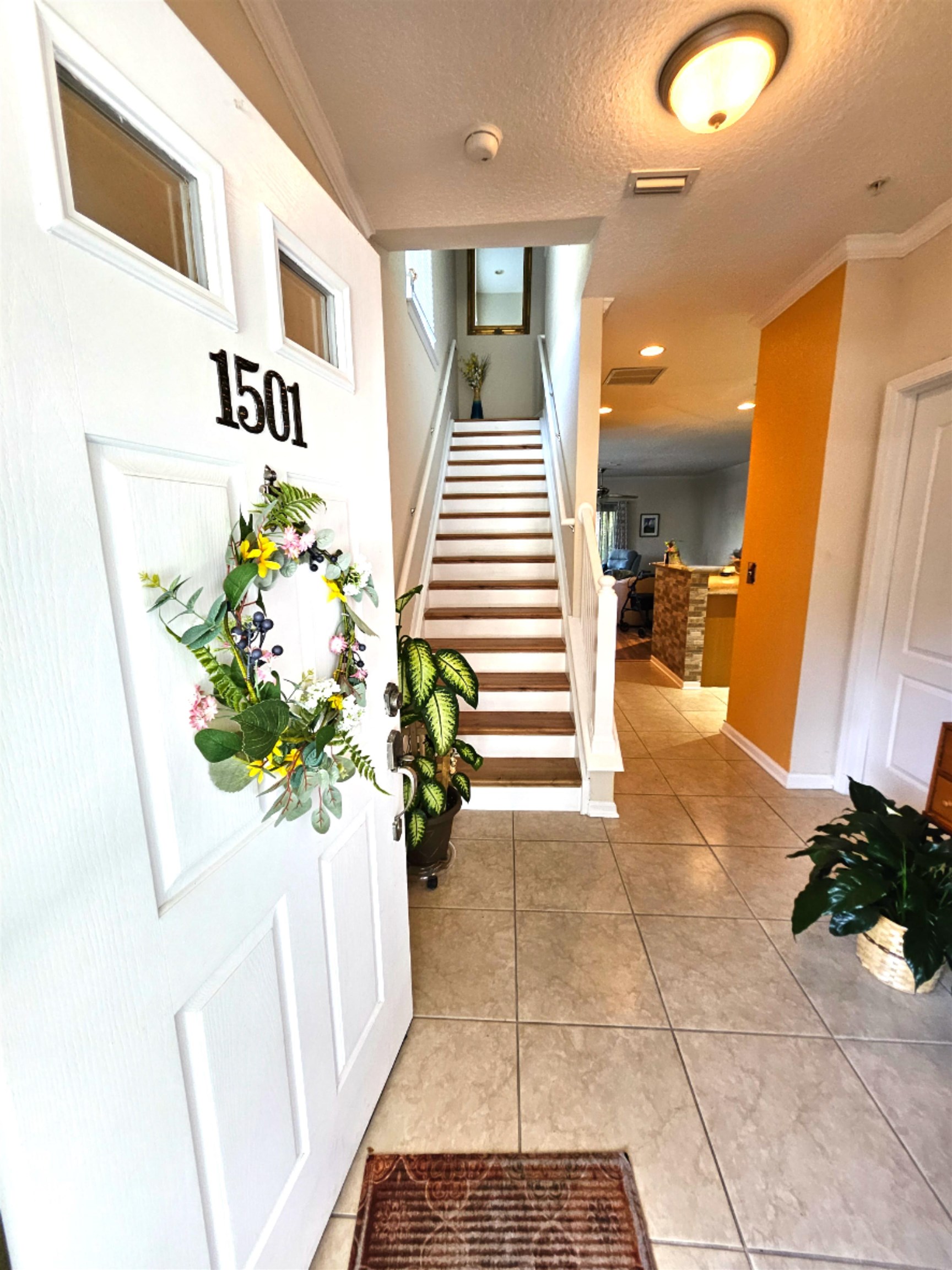 a lobby with a potted plant and a rug