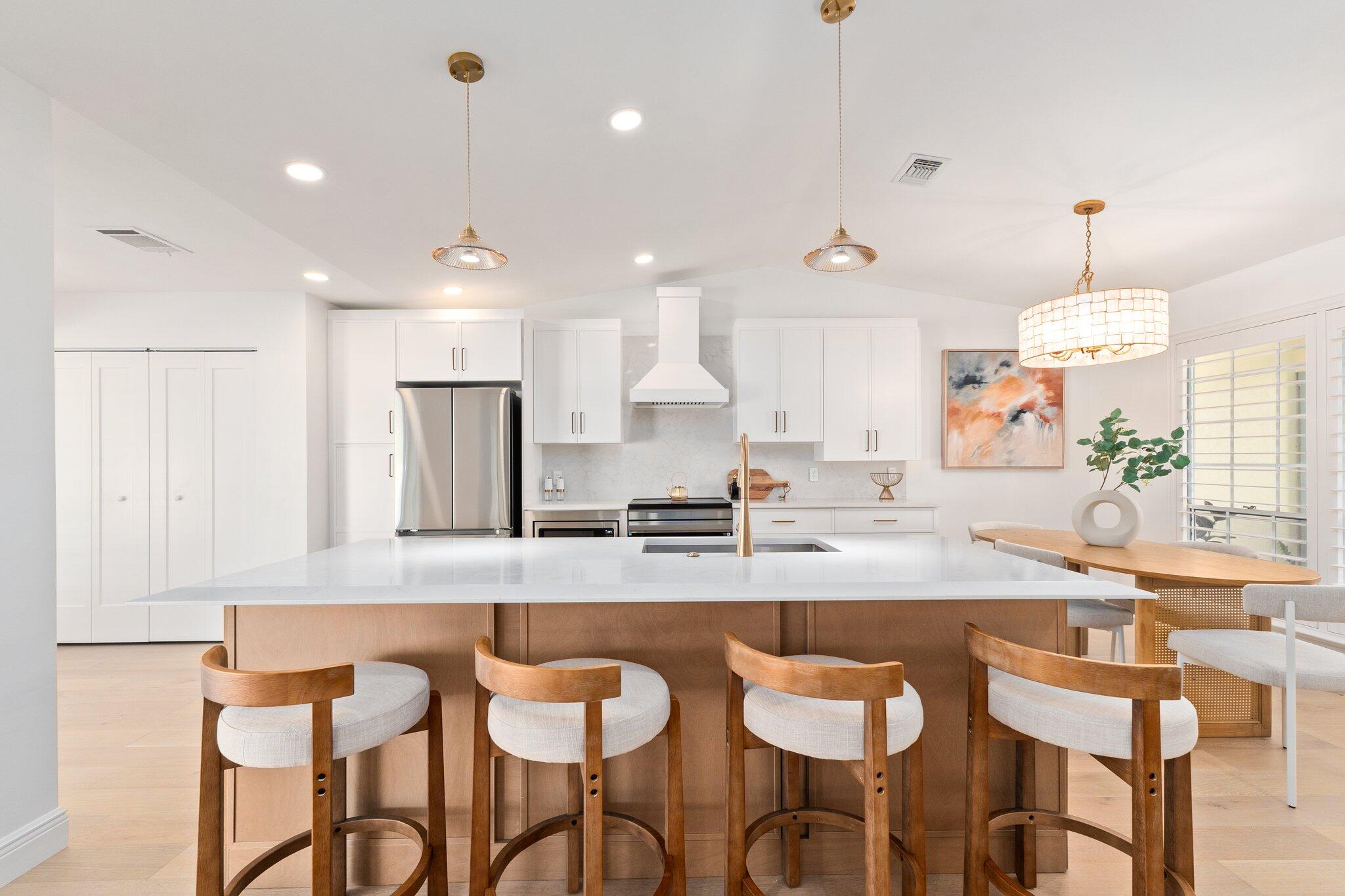 a kitchen with stainless steel appliances kitchen island granite countertop a table and chairs in it