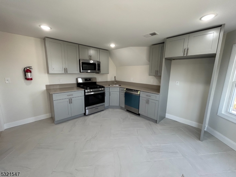 a kitchen with stainless steel appliances granite countertop a refrigerator sink and stove