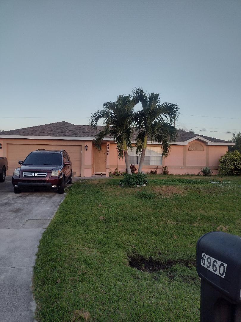 a front view of a house with a garden and parking space