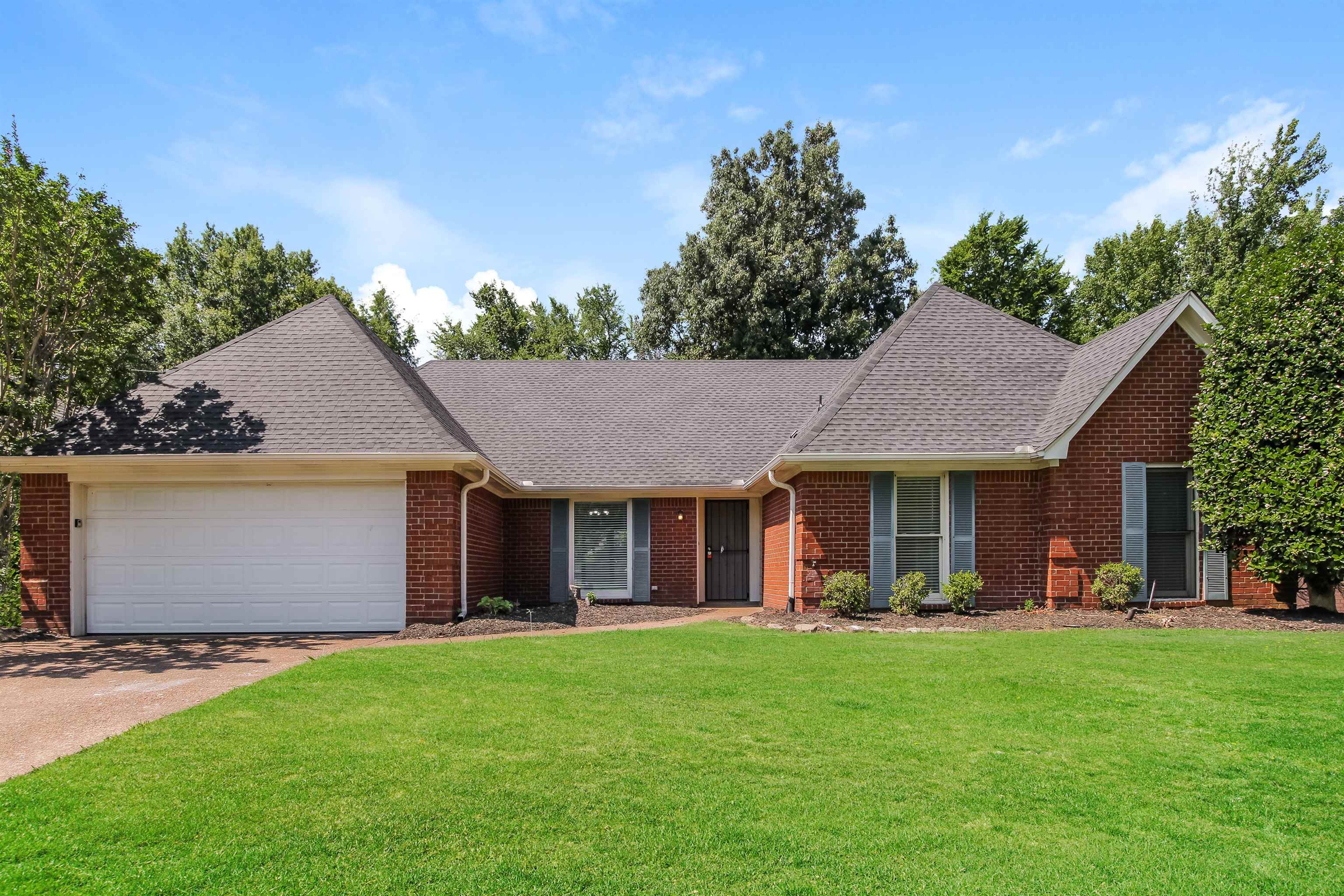 Ranch-style home featuring a garage and a front yard