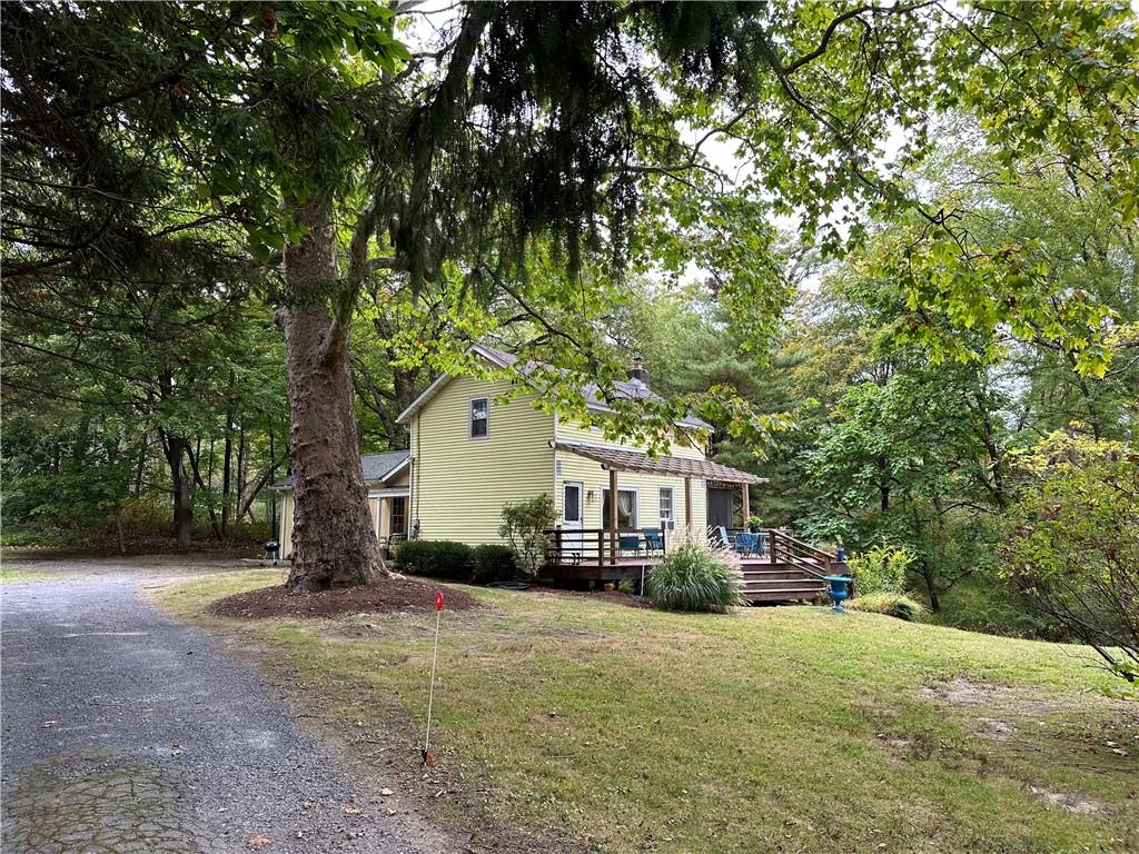 View of front of home featuring a deck and a front lawn