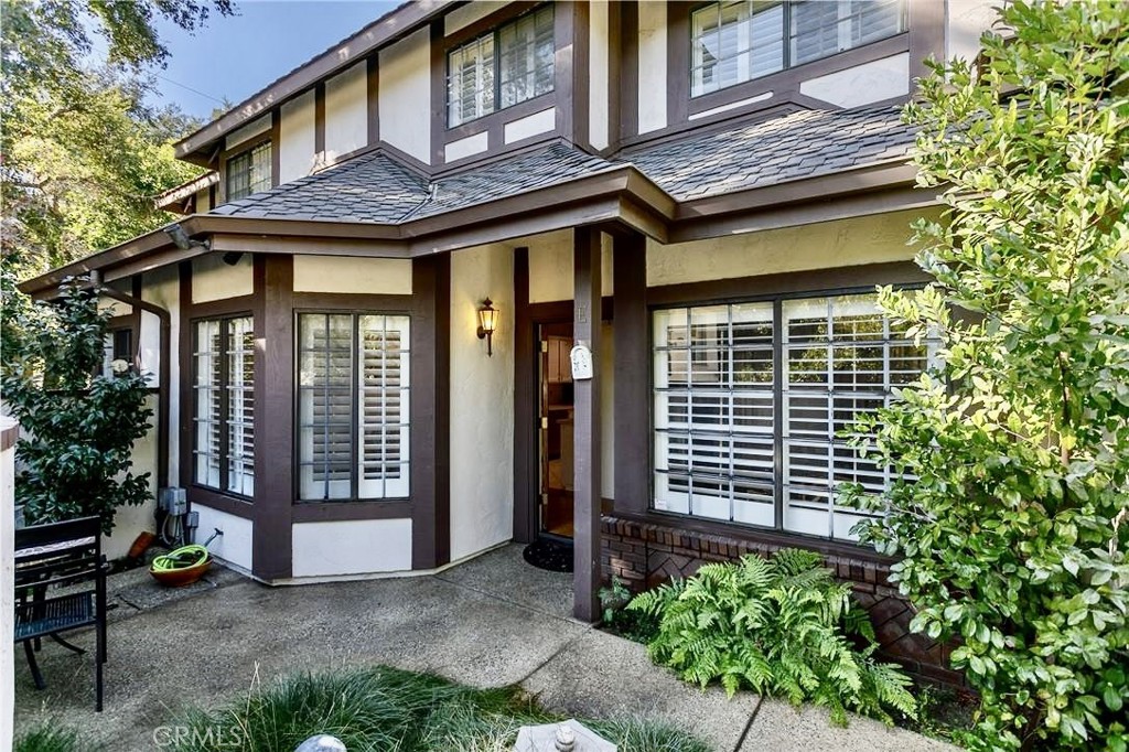 a view of a house with a large window and potted plants