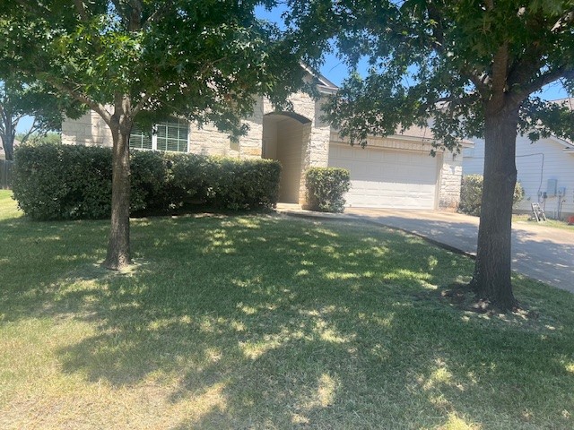 a view of a house with a yard garage and tree