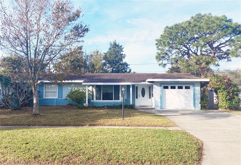 a front view of house with yard and trees around