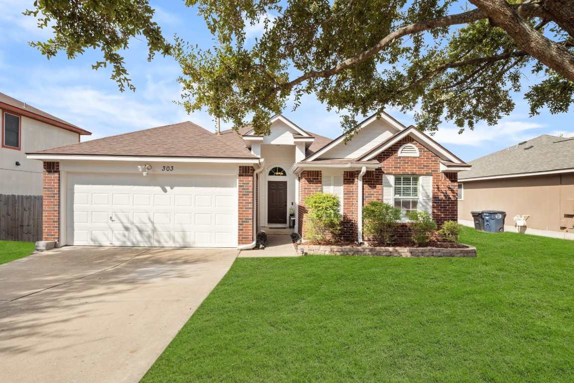 a front view of a house with a yard and trees