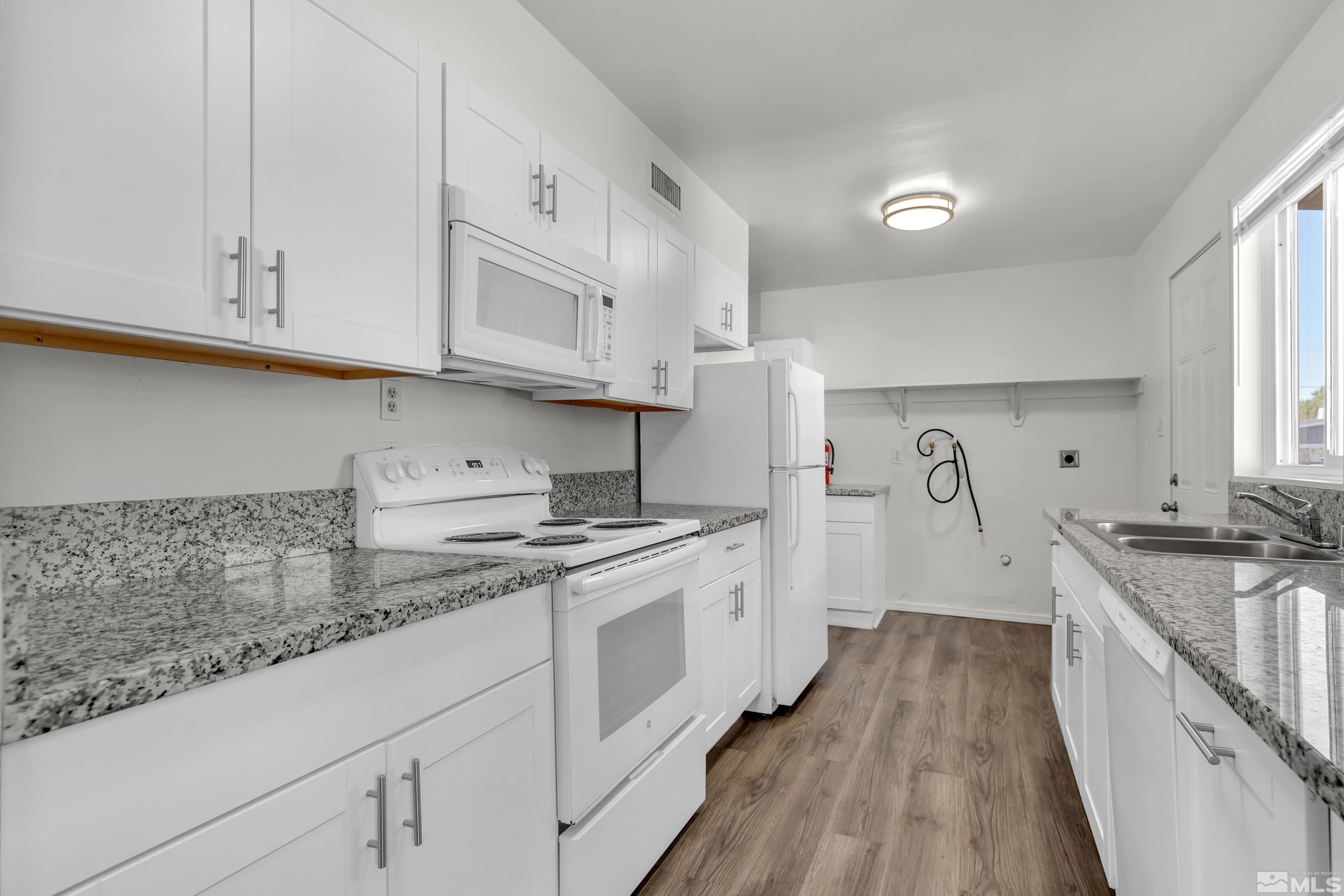 a kitchen with cabinets and wooden floor