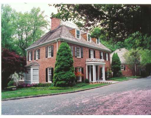 a front view of a house with a yard and trees