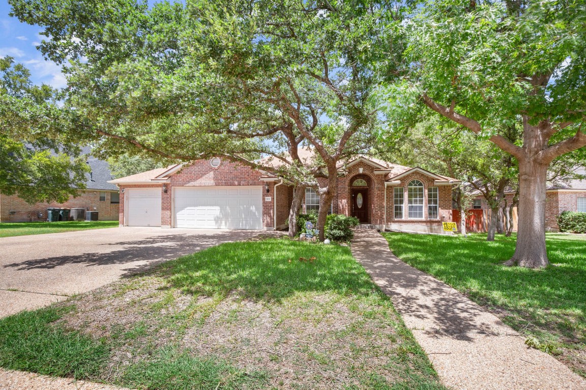 a front view of a house with yard and green space