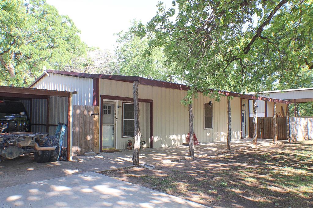 a view of a house with backyard and trees