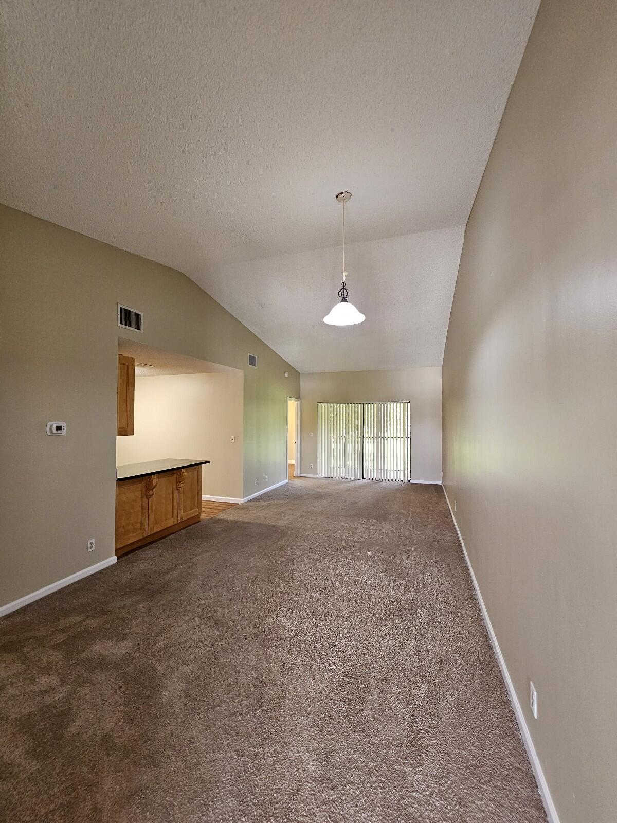 an empty room with windows and ceiling fan