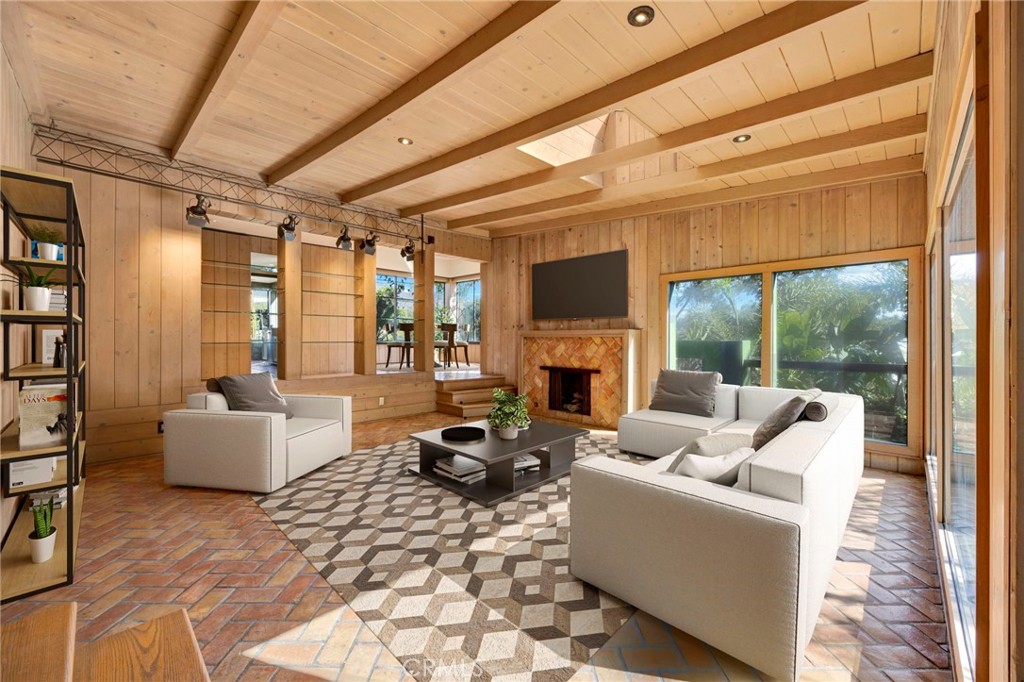 a living room with furniture large windows and wooden floor