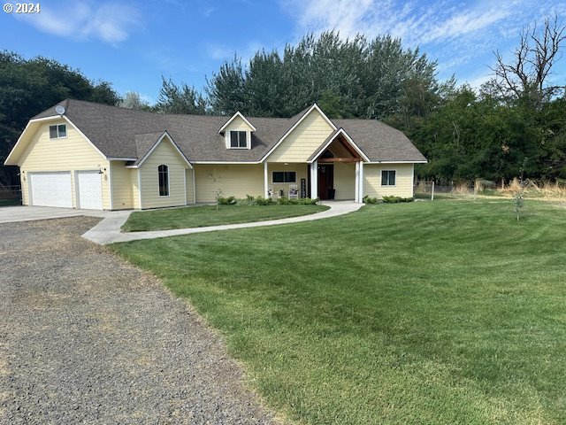 a front view of a house with a yard and trees