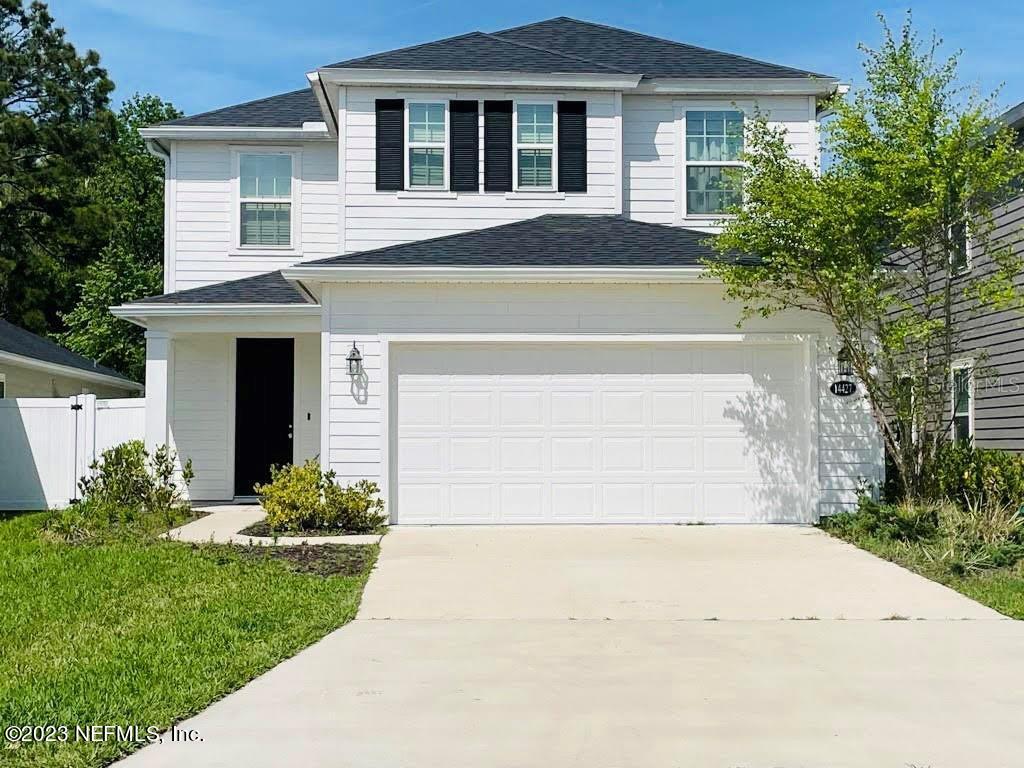 a front view of a house with a yard and trees