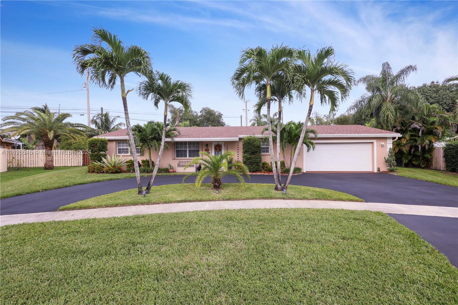 a palm tree sitting in front of a house with a yard and palm trees