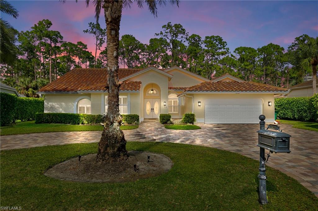 Mediterranean / spanish home featuring a lawn and a garage