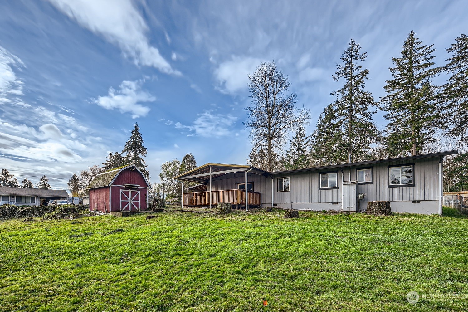 a view of a house with a big yard plants and large trees