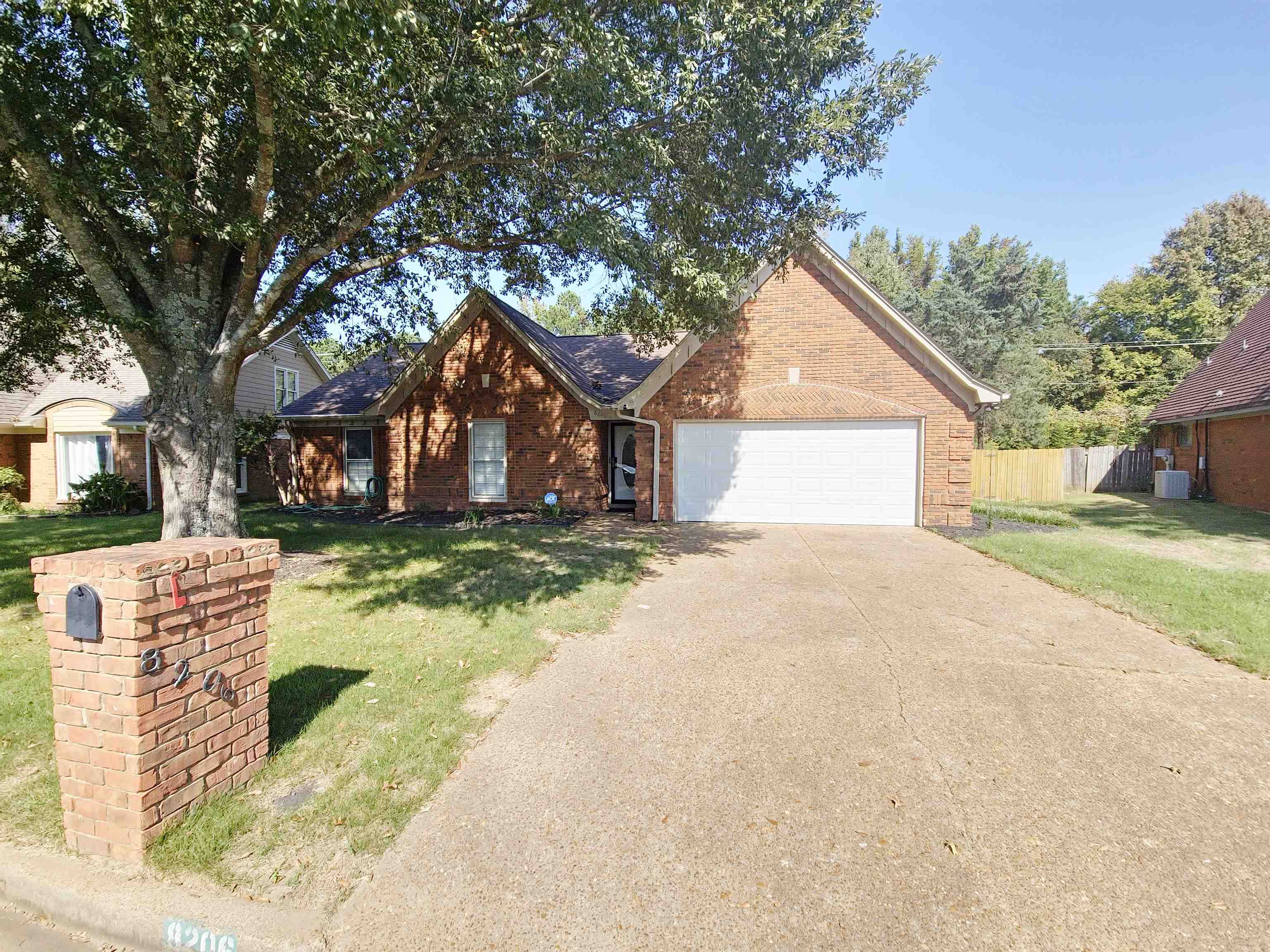 View of front of home with a front yard, central AC, and a garage