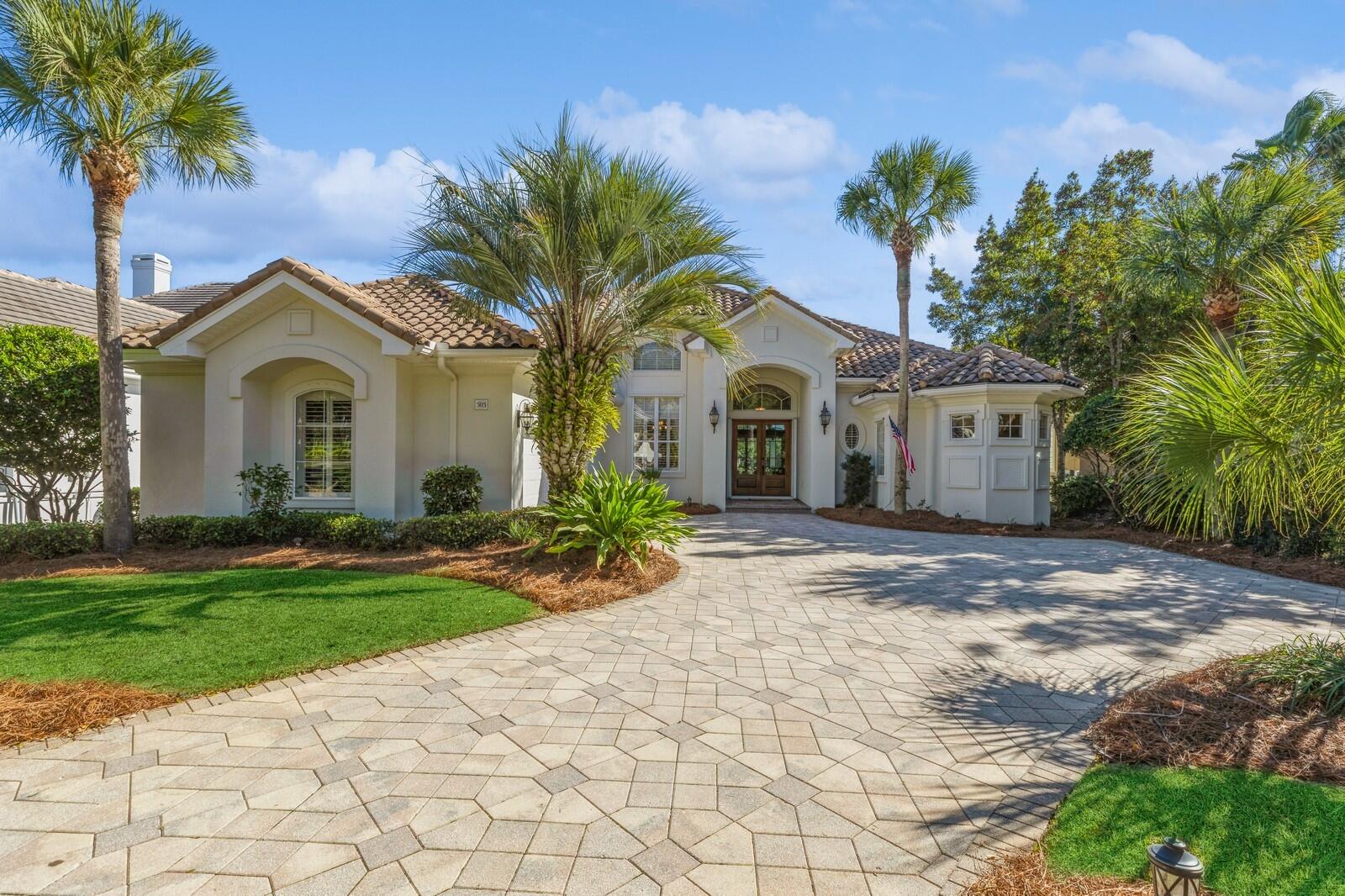 a front view of a house with a garden and trees