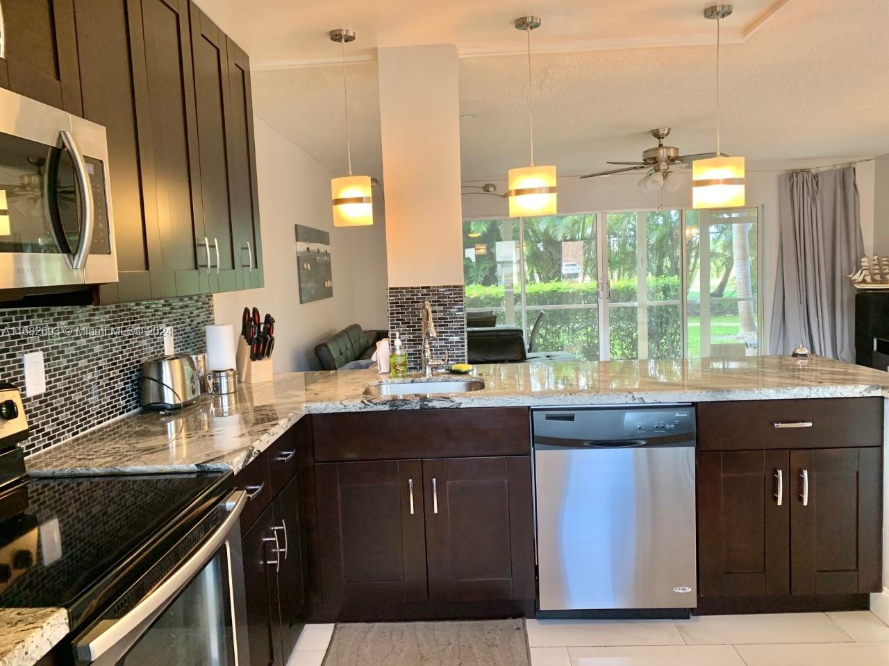 a kitchen with stainless steel appliances granite countertop a sink stove and cabinets