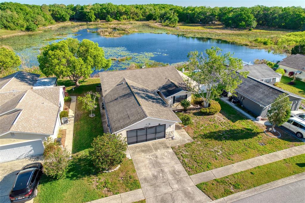 an aerial view of a house with a yard and lake view