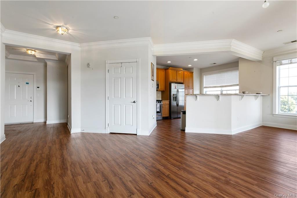 a view of a kitchen with wooden floor and a refrigerator