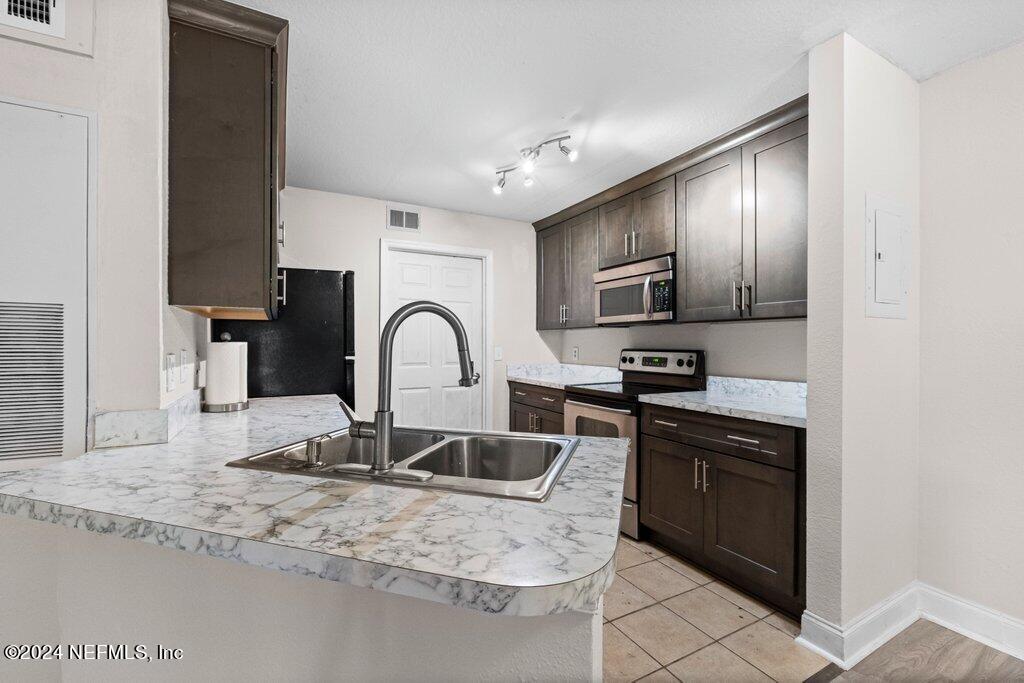 a kitchen with granite countertop stainless steel appliances and a sink