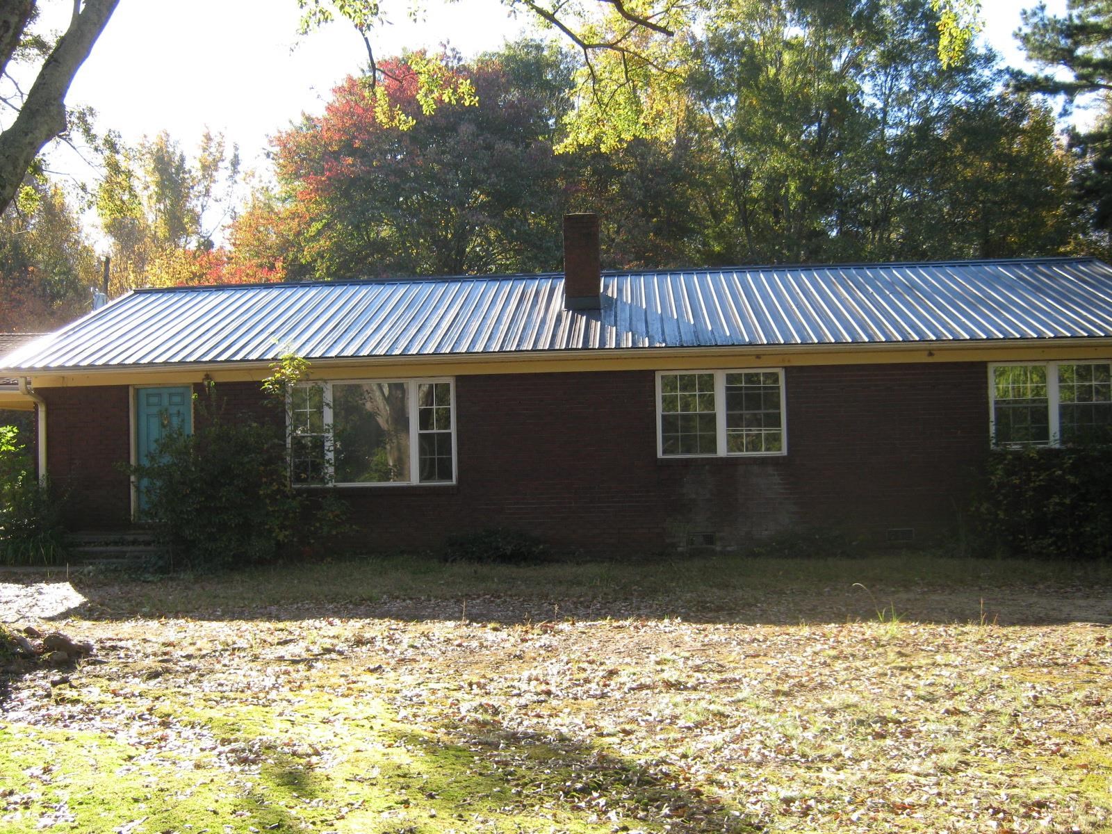 brick ranch house with metal roof