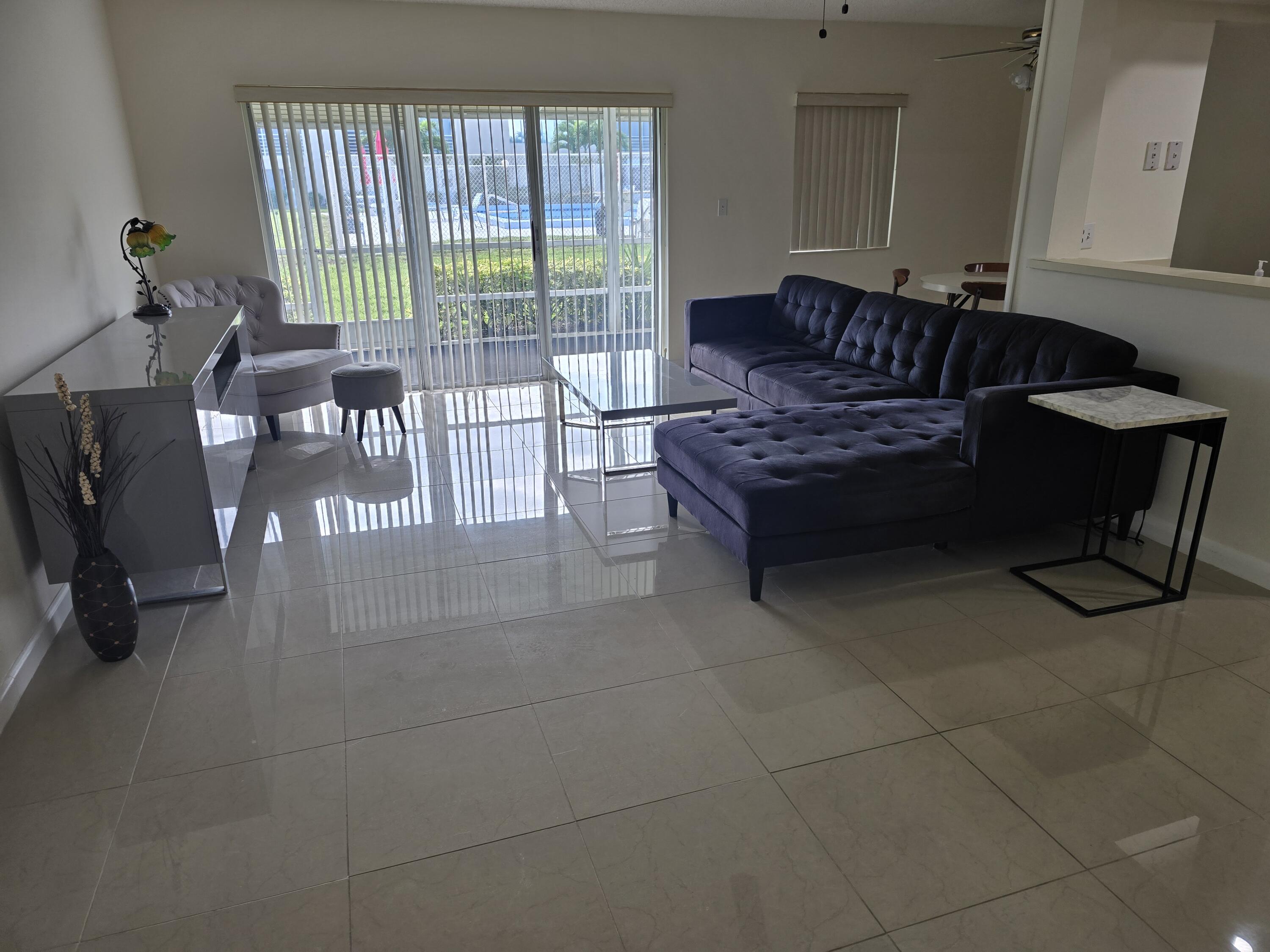 a living room with furniture and a floor to ceiling window