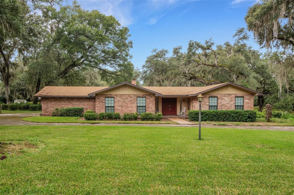 a front view of a house with a yard and trees