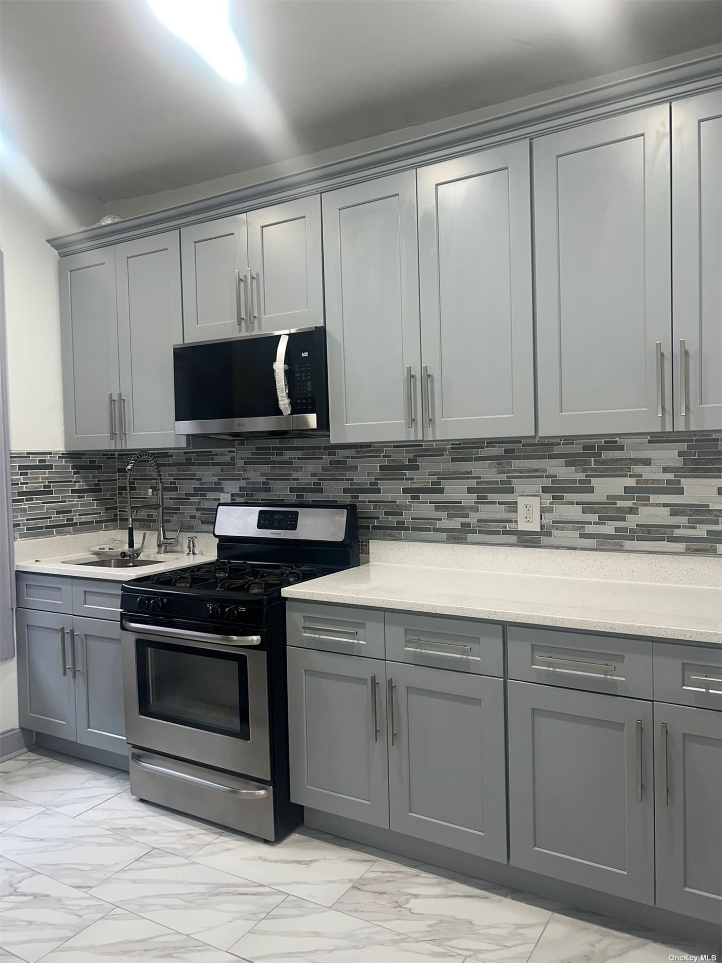 a kitchen with stainless steel appliances granite countertop a stove and a microwave