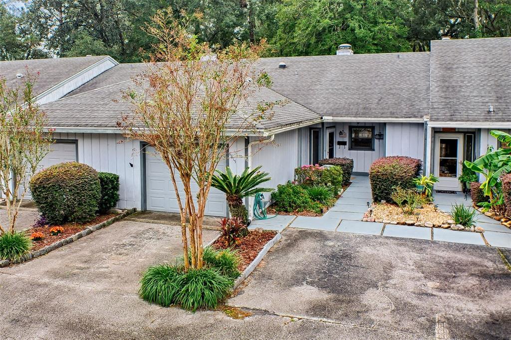 a front view of a house with garage and plants