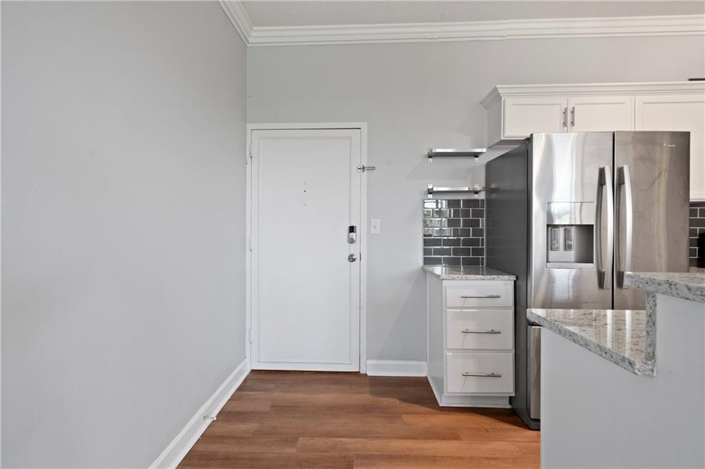 a view of kitchen with cabinets and refrigerator