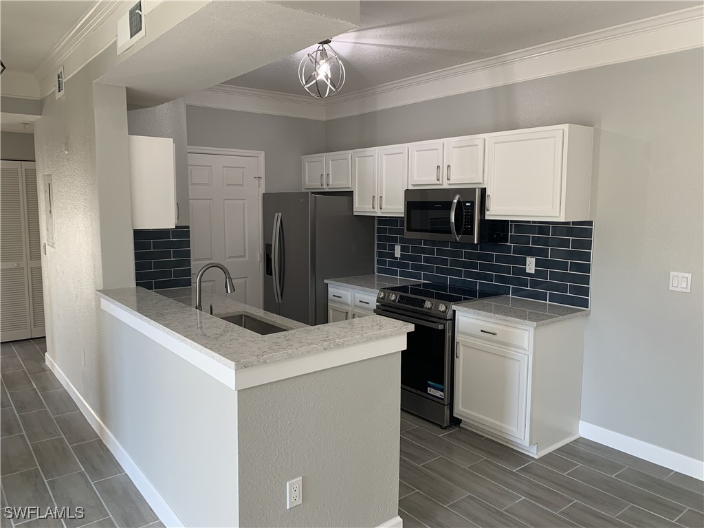 a kitchen that has a sink stainless steel appliances and cabinets